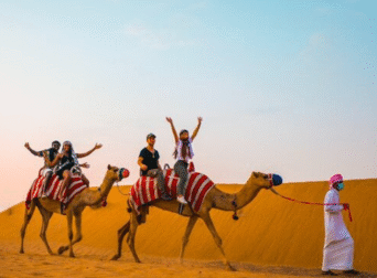 Tourists enjoying innovative desert safari activities in Dubai 2025 with camel rides and adventure sports.